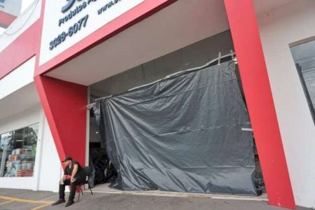 Vento forte estoura vitrine e porta de empresa agropecuária durante temporal