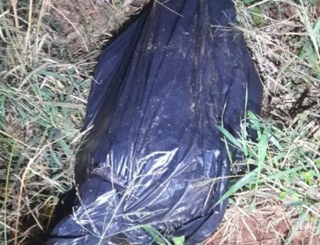 Corpo enrolado em lona preta é encontrado em área de mata